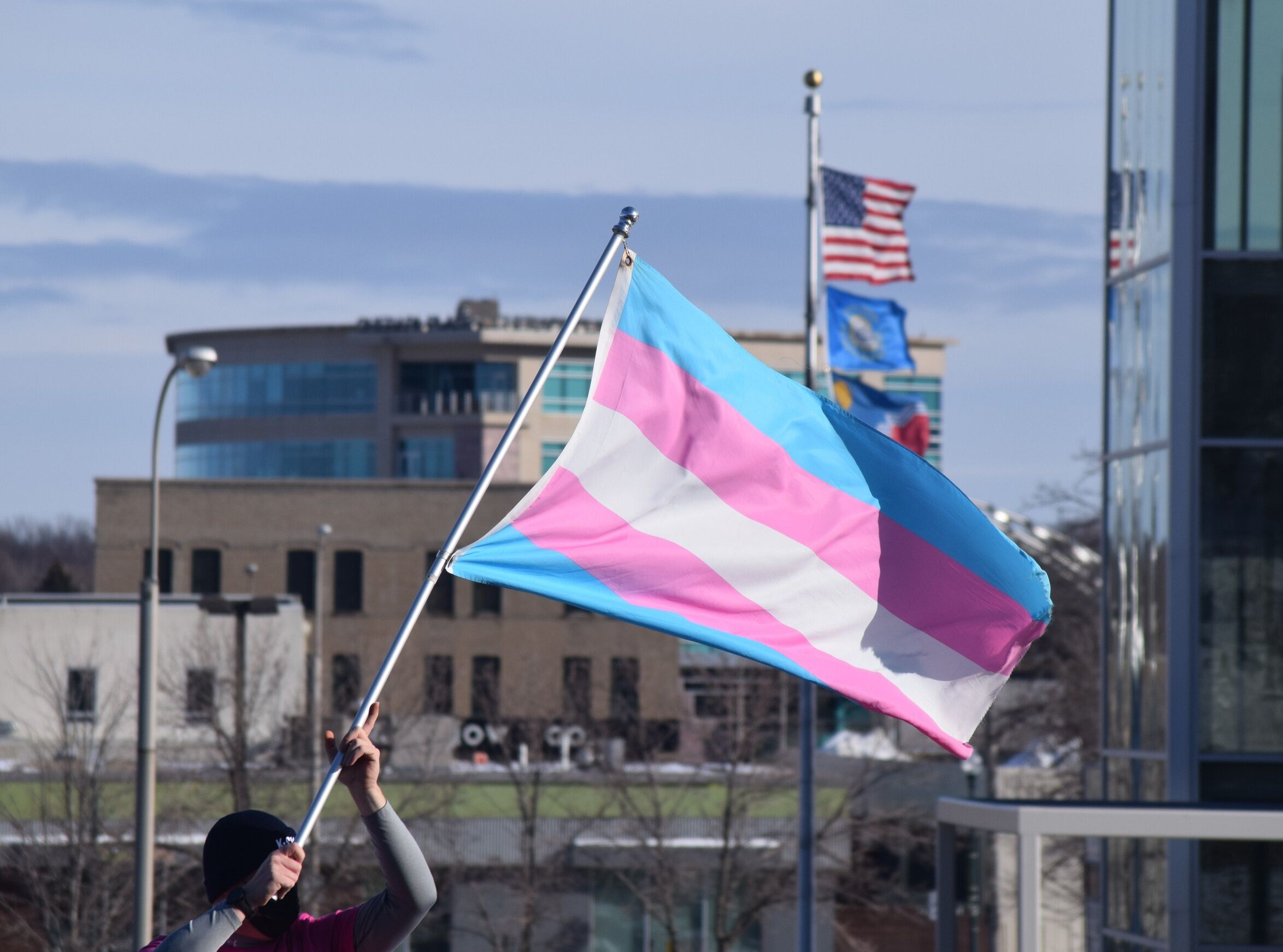 A protester holds a transgender pride flag in downtown Sioux Falls as part of a rally on January 16, 2022 in support of transgender rights