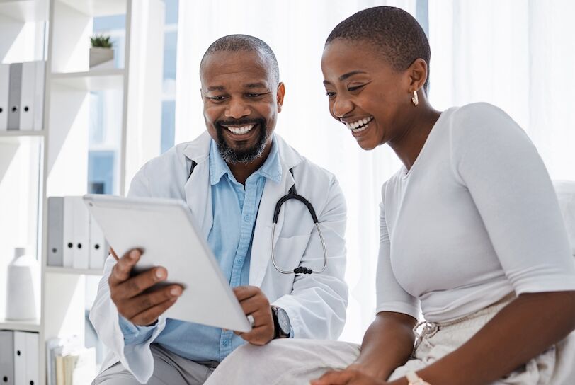 Doctor, healthcare and medicine with a patient talking test results and progress on a tablet in a hospital clinic. Trust, help and medical consulting with a professional medicare worker in his