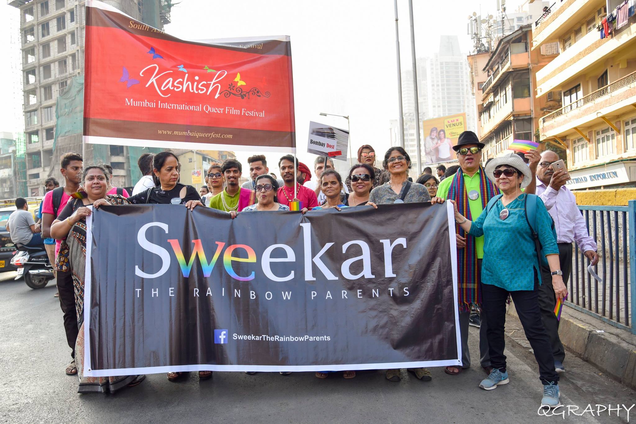 Members of Sweekar stand behind a banner