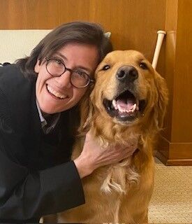 An image of Judge Ana C. Reyes hugging her dog