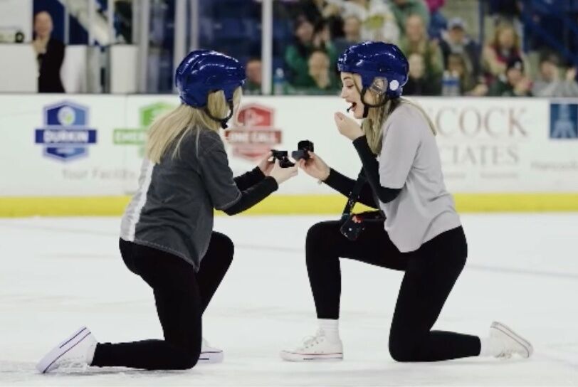 Fans stand & cheer as two women propose during pro-ice hockey game ...