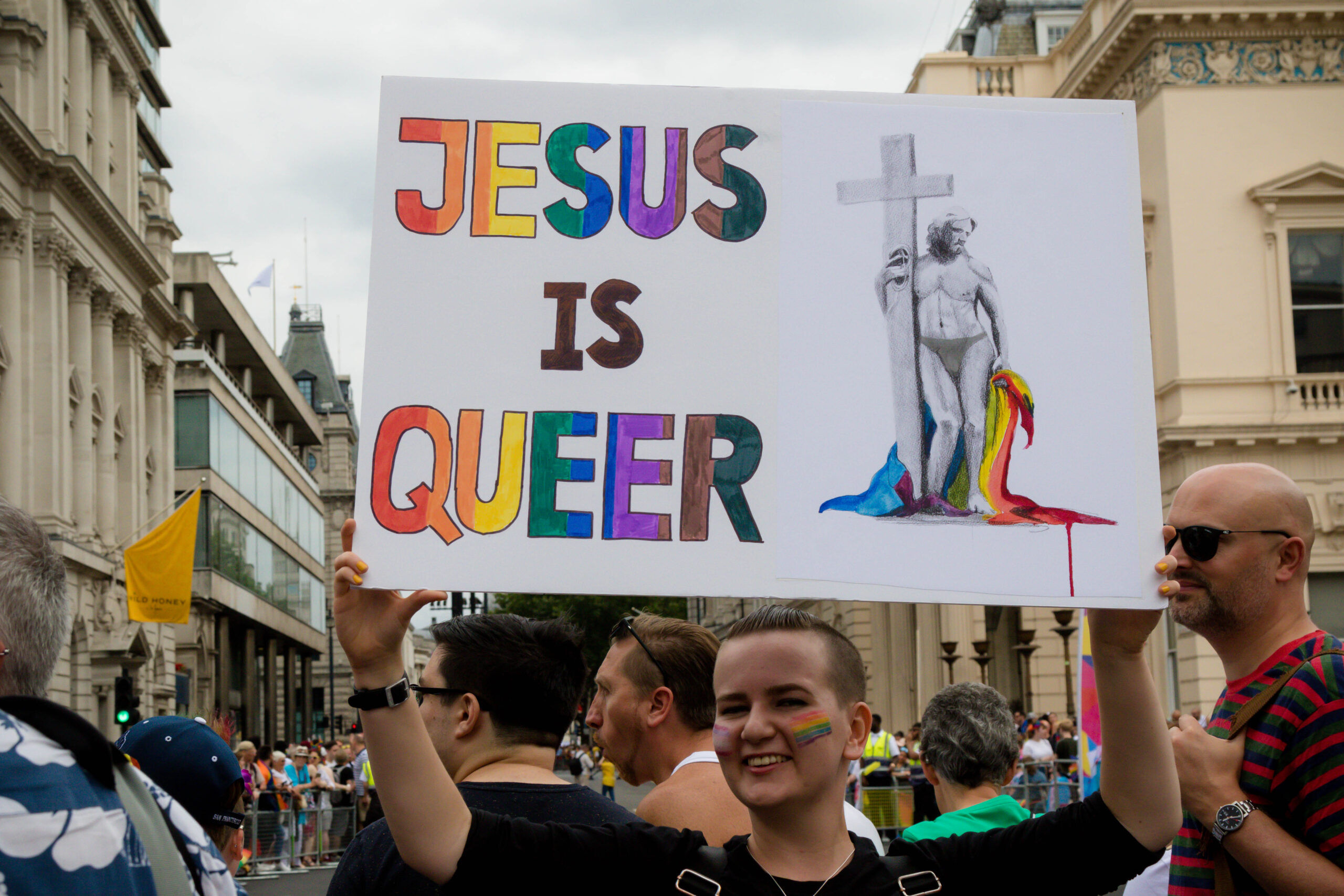 London, United Kingdom, 6th July 2019:- Participant in London Pride 2019 holding a sign reading jesus is Queer