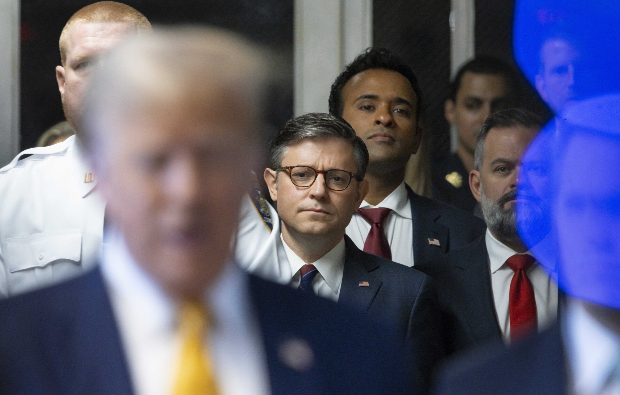 May 14, 2024; New York, NY: Speaker of the House Mike Johnson (center), and Vivek Ramaswamy (right) look on while former President Donald Trump speaks to the media alongside his lawyer Todd Blanche before his criminal trial