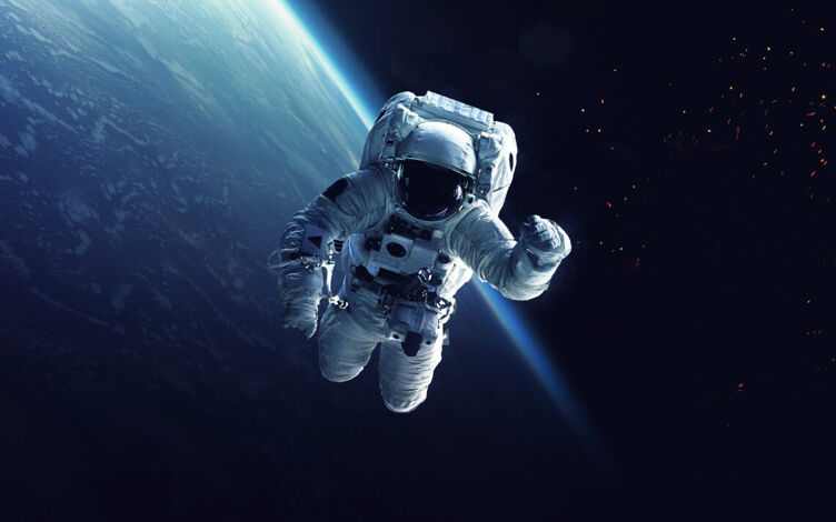 An astronaut spacewalks above Earth