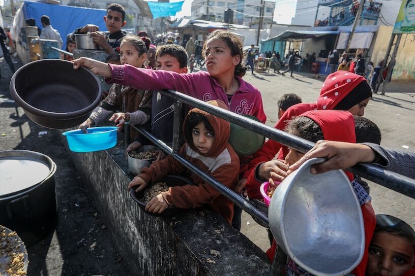 Aid workers give food to Palestinians in the Gaza Strip in February 2024