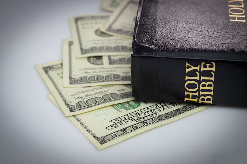 Holy Bible and money. Hundred dollars