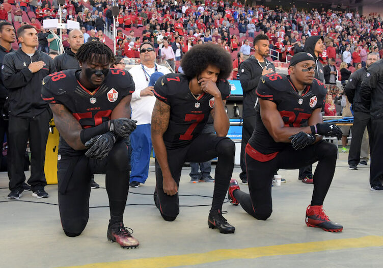Oct 6, 2016; Santa Clara, CA, USA; San Francisco 49ers outside linebacker Eli Harold (58), quarterback Colin Kaepernick (7) and free safety Eric Reid (35) kneel in protest during the playing of the national anthem before a NFL game against the Arizona Cardinals at Levi's Stadium. Mandatory Credit: Kirby Lee-USA TODAY Sports