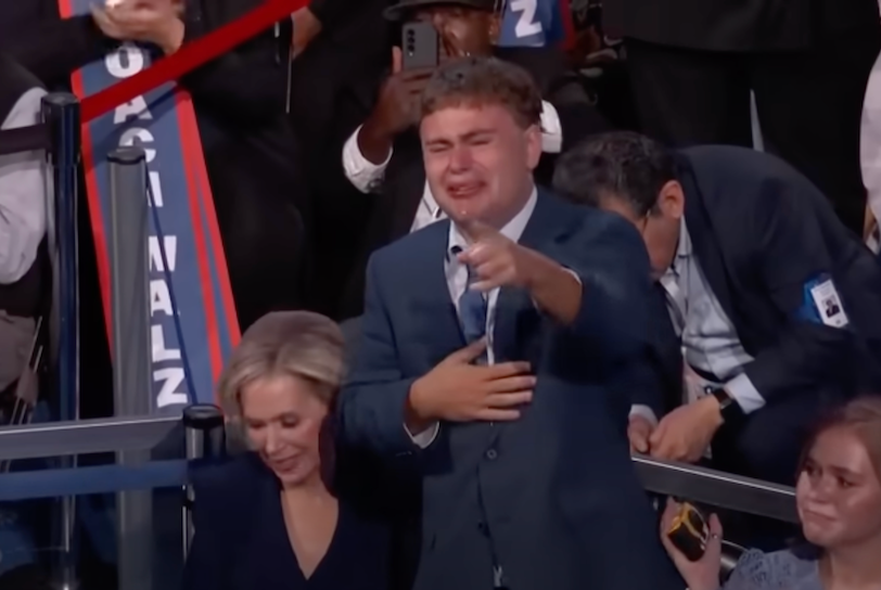 Gus Walz stands up and tearfully, proudly points to his father, Minnesota Gov. Tim Walz (D) during the 2024 Democratic National Convention.