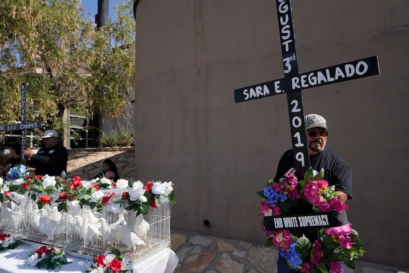 Volunteers with the Border Network of Human Rights carry crosses with the names of the victims of the Aug. 3 El Paso Walmart shooting at a memorial on the massacre's fifth anniversary.