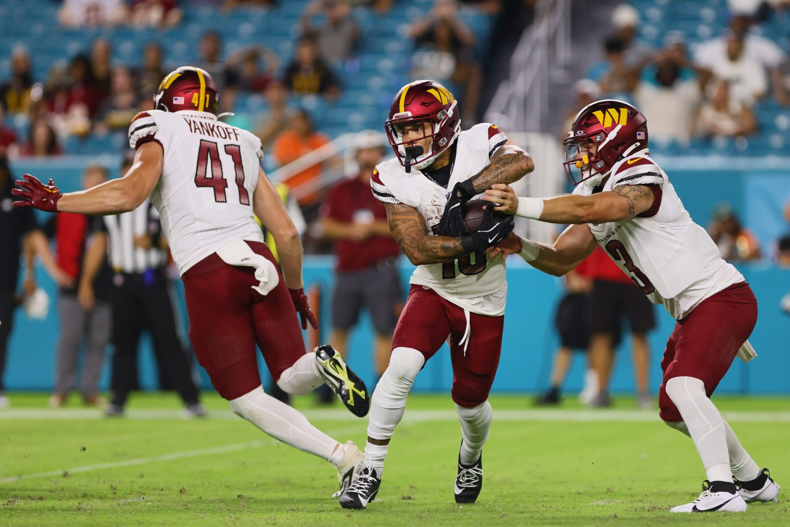 August 17, 2024; Miami Gardens, Florida; Washington Commanders wide receiver Kazmeir Allen (10) takes a handoff from Washington Commanders quarterback Trace McSorley (3) during the fourth quarter of a preseason game at Hard Rock Stadium