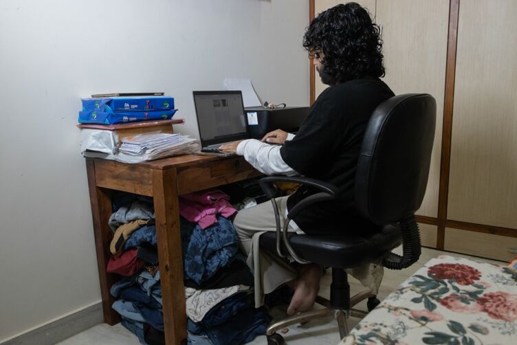 Dee works on her laptop, and manages online orders from her bedroom.