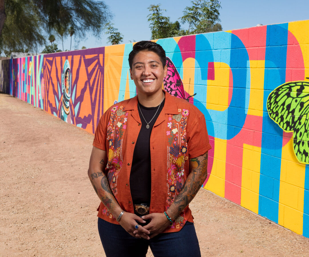 Arizona state representative Lorena Austin stands in front of a mural.