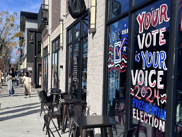 A store window paiting with a message that reads "your vote is your voice."