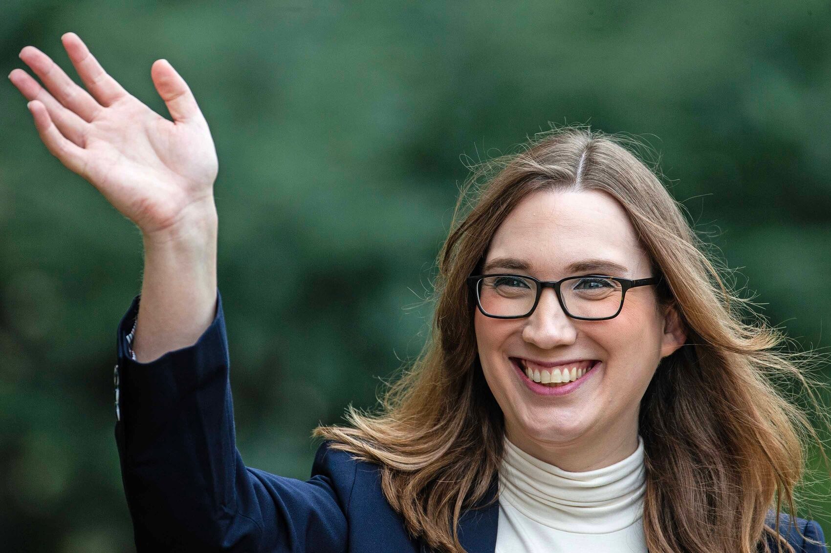 Sen. Sarah McBride waves at neighbors outside her home in Wilmington, Tuesday, October 1, 2024.