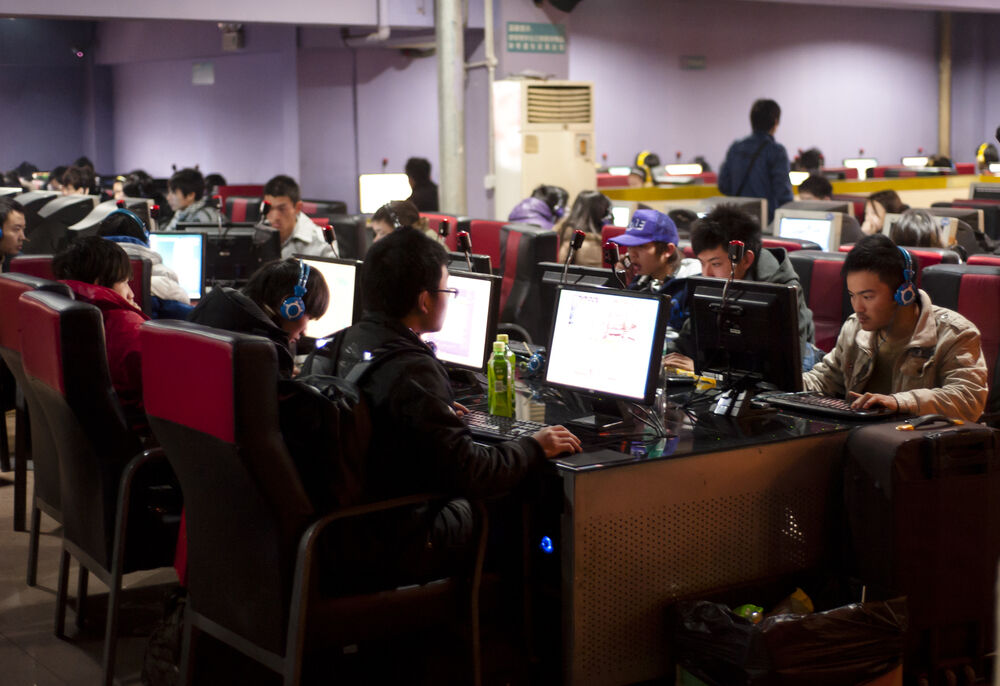 Young Chinese people use computers and play online video games in the interior room of a internet cafe in Chengdu, China