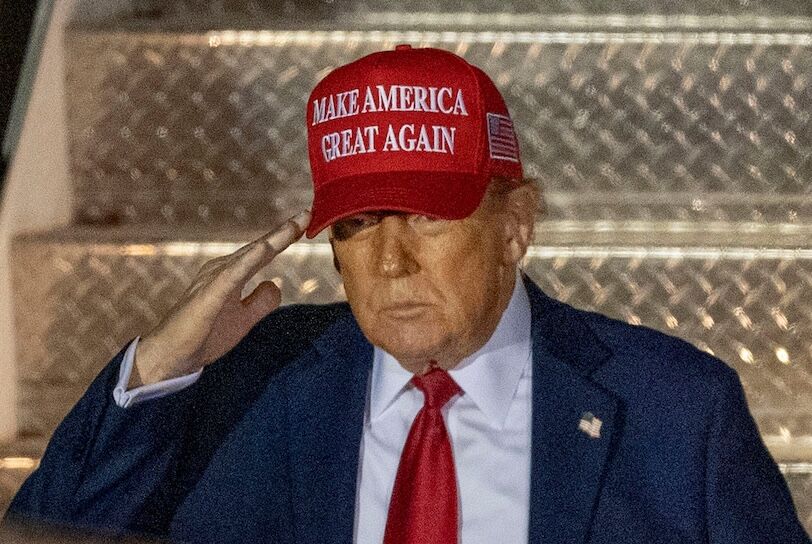 USATSI_25753392 The president salutes while wearing a red ballcap that says "Make America Great Again."