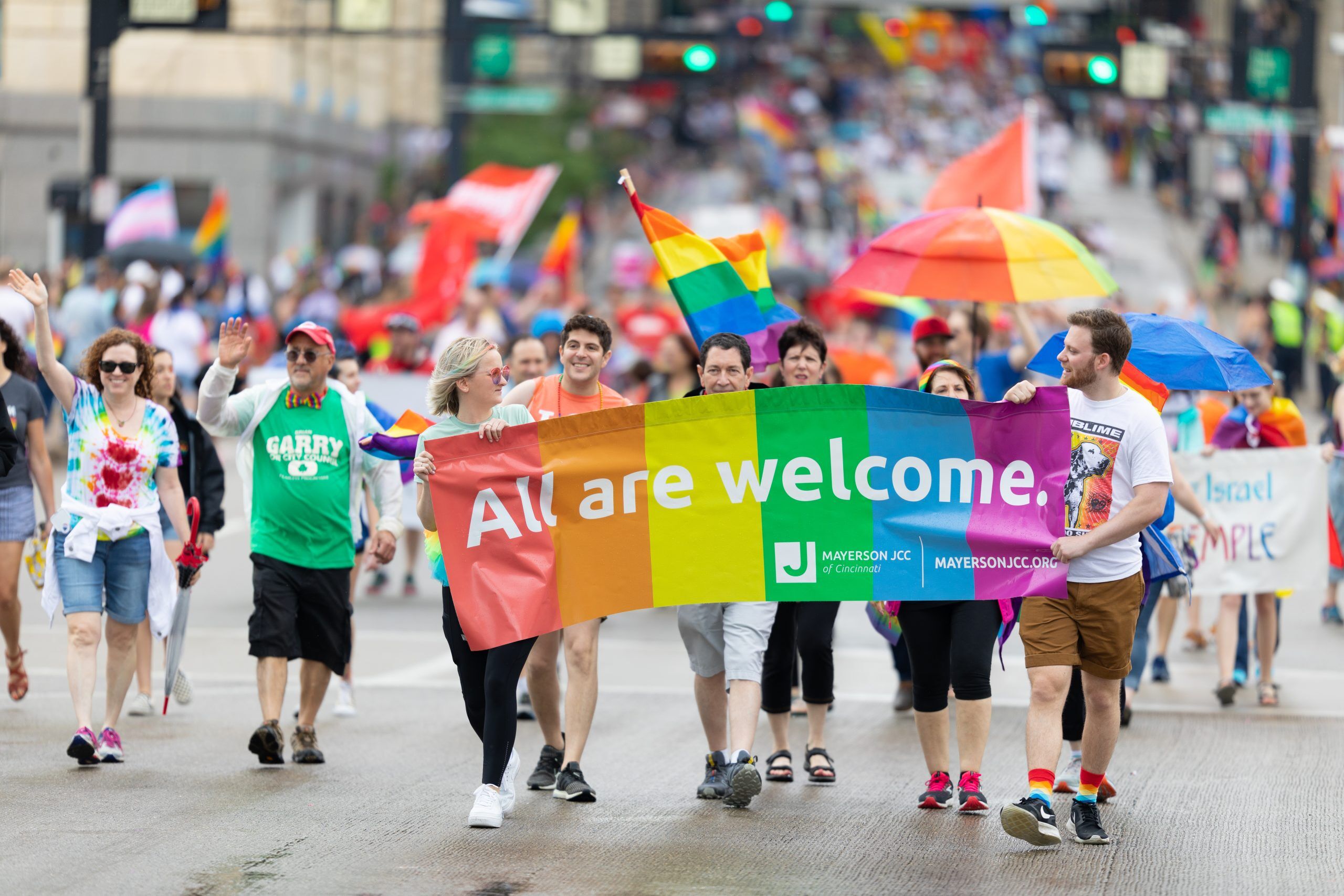shutterstock_1632717910 Cincinnati, Ohio, USA - June 22, 2019: The Cincinnati Pride Parade, People Carrying a banner that says, All are welcome, promoting Mayerson JCC