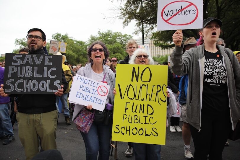 Activists at the Texas state capitol protest a school voucher plan promoted by Gov. Greg Abbott that funds charter, including religious, schools with state taxes.