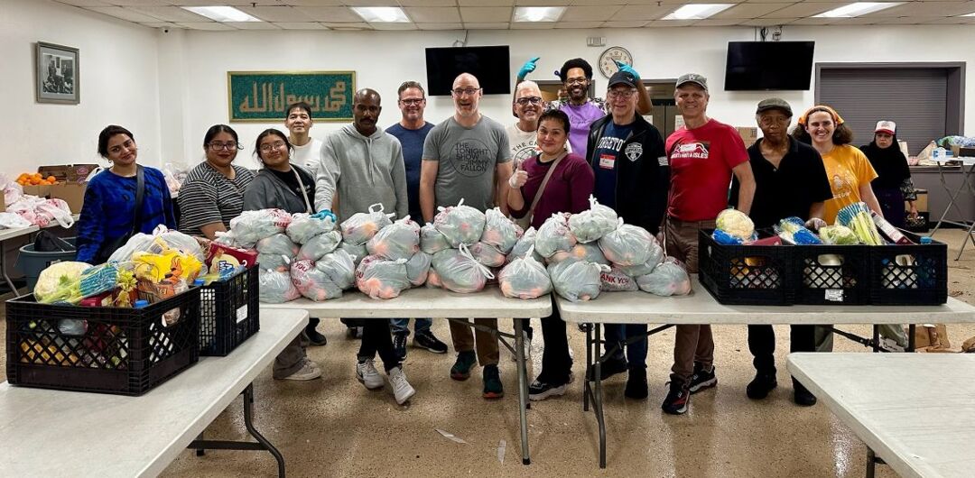 Members of the Los Angeles chapter of G4G stand alongside volunteers with the L.A. Islamic Center while displaying the food baskets they've prepared for distribution.