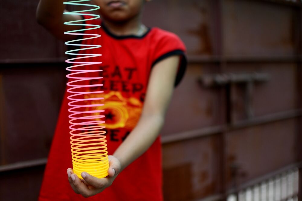 A child holding a plastic Slinky coil.