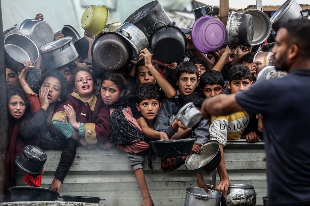 Displaced Palestinians in Al-Mawasi crowd to get rice meals from (Al-Takiya) due to the lack of flour and also the lack of entry of aid, in the southern Gaza Strip, on November 29, 2024