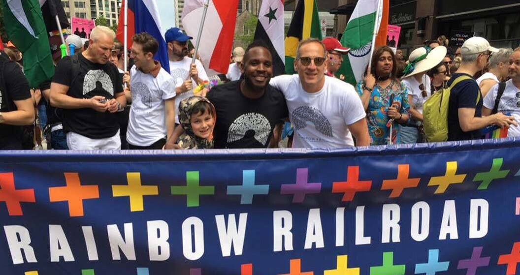 Supporters of Rainbow Railroad show the group's banner at a Pride event.